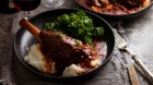 Lamb shanks cooked in red wine sauce and served with mashed potato and kale.