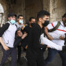 Palestinians evacuate a wounded protester during clashes with Israeli security forces at the Lions Gate in Jerusalem’s Old City, Monday, May 10, 2021.