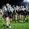 Tom Jonas, Karl Amon and Port players walk off with the Showdown Trophy after beating Adelaide on Saturday night.