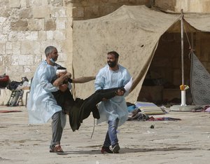 Palestinians evacuate a wounded man during clashes with Israeli security forces at the Al-Aqsa Mosque compound in Jerusalem's Old City Monday, May 10, 2021.