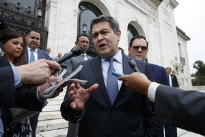 In this Aug. 13, 2019 file photo, Honduran President Juan Orlando Hernandez speaks to reporters as he leaves a meeting at the Organization of American States, in Washington.