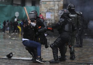 A protester clashes with the police during an anti-government protest in Bogota, Colombia, Wednesday, May 5, 2021