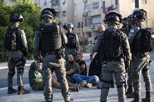 Israeli paramilitary border police detain Jewish settlers, during clashes between Arabs, police and Jews, in the mixed town of Lod, central Israel, Wednesday, May 12, 2021.