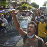 Anti-coup protesters shout slogans during a flash-mob demonstration earlier this month in Yangon, Myanmar.