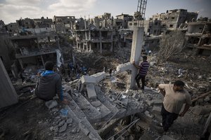 Palestinians inspect their destroyed houses following overnight Israeli airstrikes in town of Beit Hanoun, northern Gaza Strip, Friday, May 14, 2021.