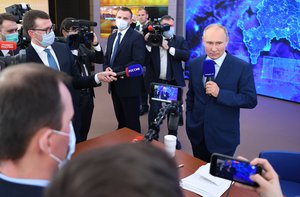 Russian President Vladimir Putin, right, speaks to journalists after his news conference via video call at the Novo-Ogaryovo residence outside Moscow, Russia, Thursday, Dec. 17, 2020.