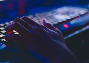 Photo of person typing computer in dark