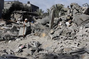 Palestinians inspect a damaged house following Israeli air strikes in the Rafah refugee camp in southern Gaza Strip on November 18, 2012. Israeli war planes hit a Gaza City media center and homes in northern Gaza in the early morning, as the death toll mounted, despite suggestions from Egypt's President Mohamed Morsi that there could be a "ceasefire soon.".Photo by Ahmad Deeb / WN