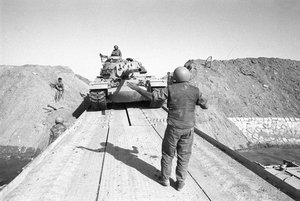 File - Israeli Tanks Cross the Suez Canal during the Yom Kippur War, 1973. The war took place mostly in Sinai and the Golan—occupied by Israel during the 1967 Six-Day War—with some fighting in African Egypt and northern Israel.