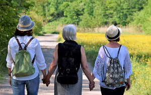 Three old woman holding hands while walking