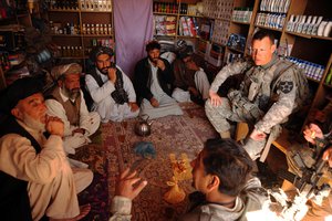 File - U.S. Army Lt. Col. Burton Shields, commander of 4th Battalion, 23rd Infantry Regiment, and his translator, hold a key leader engagement in Karezgay, Afghanistan, Oct. 31, 2009.