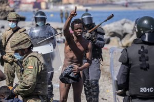 A migrant argues with Spanish security forces moments before being expelled to Morocco at the Spanish enclave of Ceuta, on Tuesday, May 18, 2021.