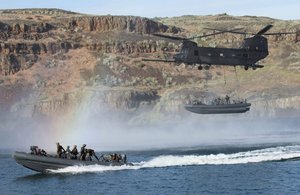 File - Special Warfare Combatant-craft Crewmen from Special Boat Team 12, stationed at Naval Base Coronado, Calif., with the help of aviators from 4th Battalion, 160th Special Operations Aviation Regiment, stationed at Joint Base Lewis-McChord, Wash., conducted a Maritime External Air Transportation System training evolution in Moses Lake, Washington.