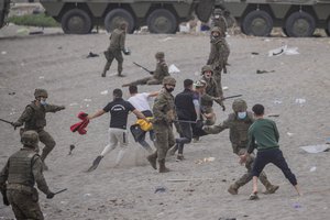 Spanish Army soldiers clash with migrants near the border of Morocco and Spain, at the Spanish enclave of Ceuta, on Tuesday, May 18, 2021