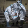 Medical workers wearing protective gear carry a patient at an infectious diseases hospital in Russia last year.