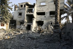 Palestinians inspect damaged buildings following overnight Israeli air strikes on the southern Gaza Strip town of Rafah on November 20, 2012. The Israeli military said it attacked about 100 targets in the coastal enclave, the Gaza Strip, during the night, using aircraft, warships and artillery.Photo by Ahmed Deeb / WN