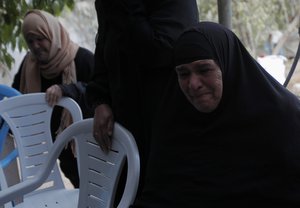 A Palestinian woman grieves during the funeral of 13-year-old Hmeid Abu Daqqa, who was killed after being hit by bullets fired from an Israeli helicopter, in Khan Yunis in the southern Gaza Strip on November 9, 2012. Israeli Defence Minister Ehud Barak blamed Hamas for a blast along the Gaza border which wounded an Israeli soldier, and said he was mulling how and when to respond. The blast came hours after Abu Daqqa was killed.Photo by Ahmed Deeb / WN