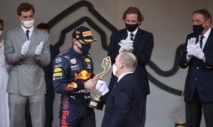 Red Bull driver Max Verstappen of the Netherlands is handed the trophy by Prince Albert II of Monaco after winning the Monaco Grand Prix at the Monaco racetrack, in Monaco,