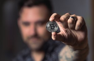 Person holding silver Bitcoin coin