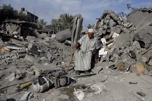 Palestinians inspect a damaged house following Israeli air strikes in the Rafah refugee camp in southern Gaza Strip on November 18, 2012. Israeli war planes hit a Gaza City media center and homes in northern Gaza in the early morning, as the death toll mounted, despite suggestions from Egypt's President Mohamed Morsi that there could be a "ceasefire soon.".Photo by Ahmad Deeb / WN