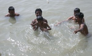 Young Boys Bath to beat the heat on the Bank of Hooghly River at North Kolkata on Monday 04 June 2012