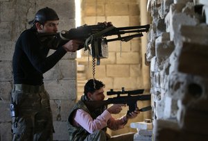 FILE - In this Tuesday Feb. 26, 2013 file photo, Free Syrian Army fighters take their positions as they observe the Syrian army forces base of Wadi al-Deif, at the front line of Maaret al-Numan town, in Idlib province, Syria.