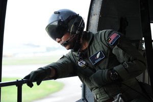 Royal Malaysian Air Force Sgt. Shahrul Naim, S-61A-4 Nuri crewman, looks out the cargo door of the helicopter during takeoff as part of a combat search and rescue exercise during Cope Taufan 2012 at TUDM Butterworth, Malaysia