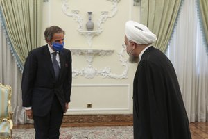 In this photo released by the official website of the office of the Iranian Presidency, President Hassan Rouhani, right, welcomes Director General of International Atomic Energy Agency, IAEA, Rafael Mariano Grossi for their meeting in Tehran, Iran, Wednesday, Aug. 26, 2020. The U.N. nuclear watchdog agency said Wednesday that Tehran has agreed to allow inspectors in to two sites where Iran is suspected of having stored or used undeclared nuclear material.