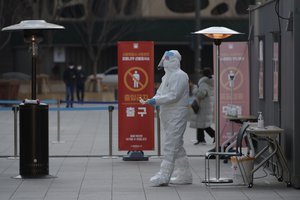 A medical worker wearing protective gears prepares to take sample in the sub-zero temperatures at coronavirus testing site in Seoul, South Korea, Monday, Dec. 21, 2020