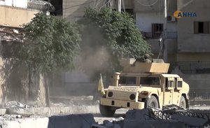 This frame grab from video released Thursday, Aug. 3, 2017 and provided by Hawar News Agency, a Syrian Kurdish activist-run media group, shows a fighter from the U.S.-backed Syrian Democratic Forces (SDF) firing his weapon during clashes with Islamic State group fighters in the northern city of Raqqa, Syria.