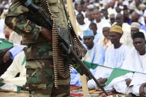 In this Thursday, Aug. 8, 2013 file photo, Nigerian soldiers stand guard during Eid al-Fitr celebrations in Maiduguri, Nigeria. Graphic new video footage from northeastern Nigeria shows the country's military carrying out abuses against civilians as part of their fight against the Islamic extremists of Boko Haram, Amnesty International said Tuesday, Aug. 5, 2014