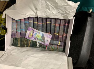 In this undated photo supplied by the New Zealand police, a box containing a large amounts of cash is seen after being discovered during a police raid as part of Operation Trojan