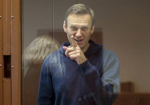 In this photo taken from a footage provided by the Babuskinsky District Court  Tuesday, Feb. 16, 2021, Russian opposition leader Alexei Navalny gestures as he stays a cage during a hearing on his charges for defamation in the Babuskinsky District Court in Moscow, Russia