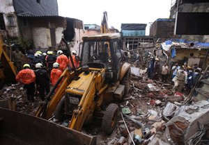 Rescuers clear the debris to find any residents possibly still trapped after a three-story dilapidated building collapsed following heavy monsoon rains n Mumbai, India, Thursday, June 10, 2021.