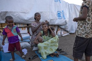 A Tigray refugee woman, who fled the conflict in the Ethiopia's Tigray, braids her friend's hair in front of their shelter at Umm Rakouba refugee camp in Qadarif, eastern Sudan, Friday, Dec. 4, 2020.