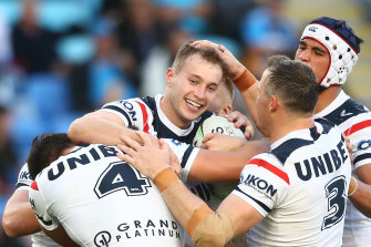 Sam Walker is mobbed by teammates after a try against the Titans.