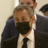 Former French President Nicolas Sarkozy, right, arrives at court in Paris.