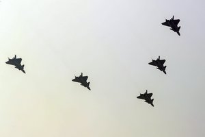 China's J-20 stealth fighter jets fly in formation over a trail colored smoke above the city center in Beijing, Sunday, Sept. 22, 2019