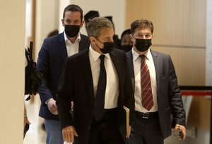 Former French President Nicolas Sarkozy, center, arrives at the court room in Paris, Tuesday, June 15, 2021