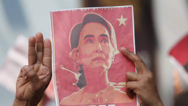 The three-finger salute, a symbol of resistance in south-east Asia, and a poster of jailed leader Aung San Suu Kyi. 