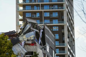 FILE - In this Friday, June 18, 2021 file photo, people look at the rubble of a building that partially collapsed in Antwerp, Belgium.