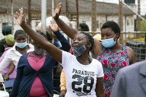 Female prsioners wave goodbye to their fellow inmates following their release from Chikurubi prison on the outskirts of Harare, Saturday,April,17, 2021