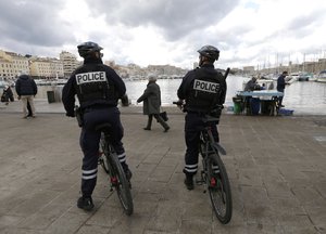 French police officers on bicycles patrol in the Christmas market, in the Old-Port of Marseille, southern France, Thursday, Dec. 7, 2017. The police strengthens the security around the places of strong influx of the public, during the Christmas time and New Year.  (AP Photo/Claude Paris)