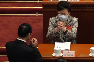 Hong Kong Chief Executive Carrie Lam, right, exchanges greetings with a fellow delegate before the opening session of China’s National People’s Congress (NPC) at the Great Hall of the People in Beijing, Friday, March 5, 2021. (AP Photo/Andy Wong)