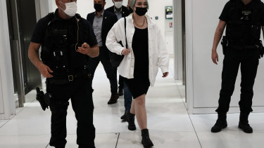 The teenager identified by her first name, Mila, leaves the courtroom in Paris. Thirteen others are charged with threatening her.