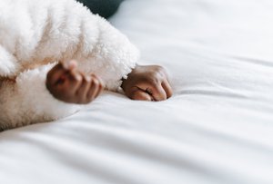 Black baby lying on comfortable bed