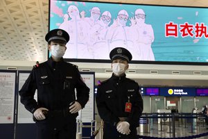 Police officers wearing face masks to protect against the spread of coronavirus stand guard at Wuhan Tianhe International Airport in Wuhan in central China’s Hubei Province,