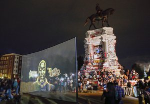 An image of George Floyd is projected on a screen in front of the statue of Confederate General Robert E. Lee on Monument Avenue Tuesday July 28, 2020, in Richmond