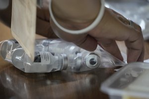 A health worker seals a bag of used Pfizer COVID-19 vials, at the city hall in Quezon city, Philippines on Monday, June 21, 2021