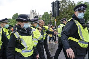 Police officers detain an anti-lockdown demonstrator in Parliament Square, London, Monday, June 21, 2021, as demonstrators gathered to protest against the delay of the next planned relaxation of coronavirus restrictions in England as a result of the spread of the delta variant first identified in India